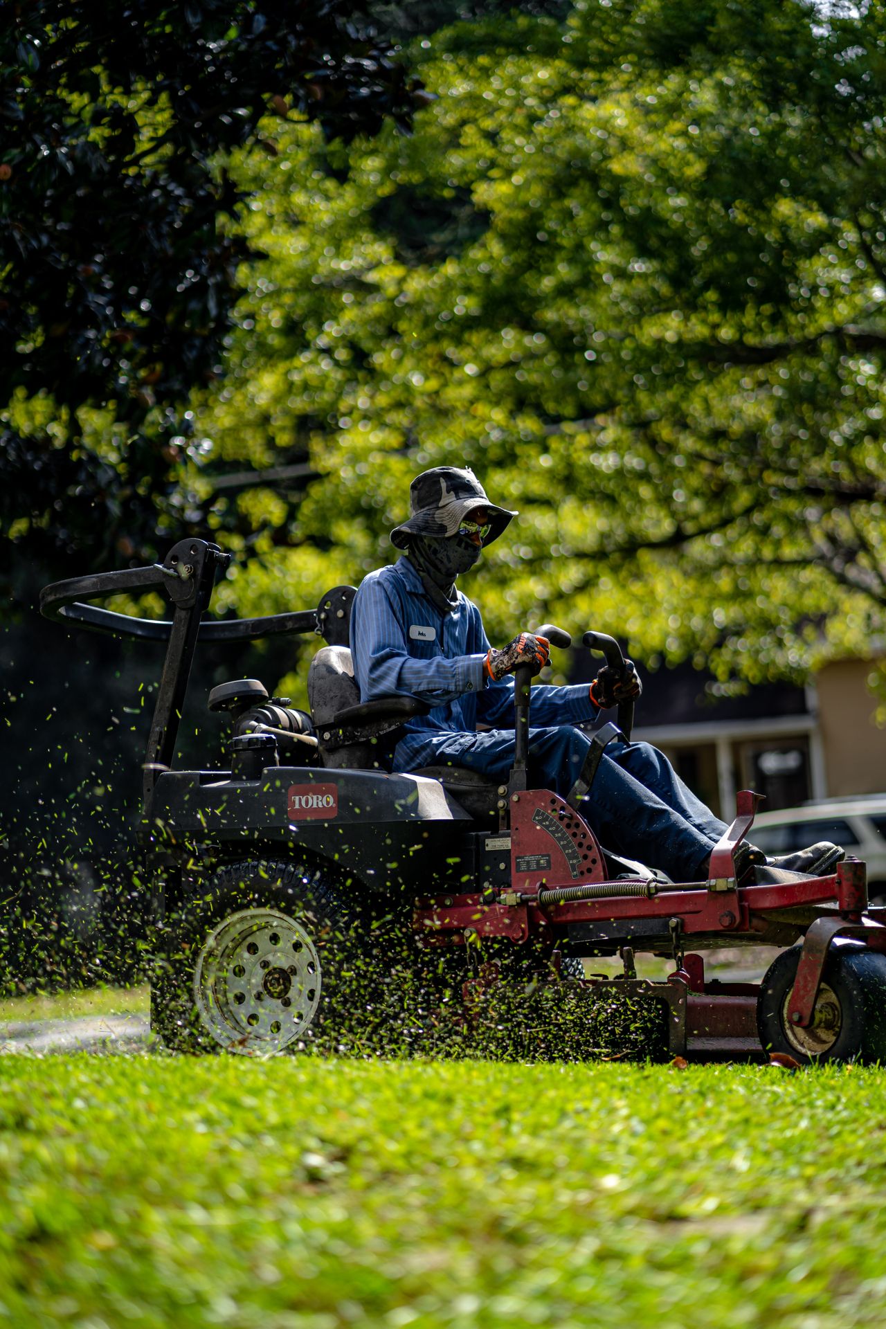 Landscaping crew member tending a manicured garden bed